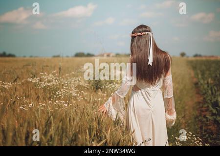 Maiden walking in a summer wheat field Stock Photo