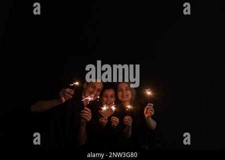 family with sparklers on a black background Stock Photo
