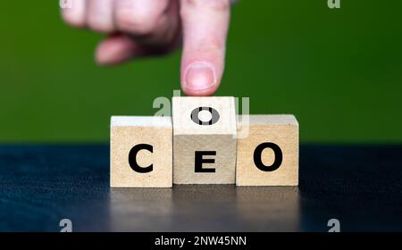 Hand turns cube and changes the abbreviation COO (chief operating officer) to  CEO (chief executive officer). Stock Photo