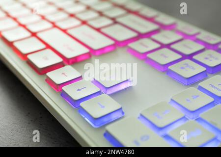 Modern keyboard with RGB lighting on grey table, closeup Stock Photo