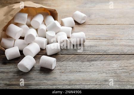 Delicious puffy marshmallows on wooden table, closeup. Space for text Stock Photo