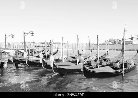 VENICE, ITALY - JUNE 13, 2019: Different gondolas at pier. Black and white tone Stock Photo