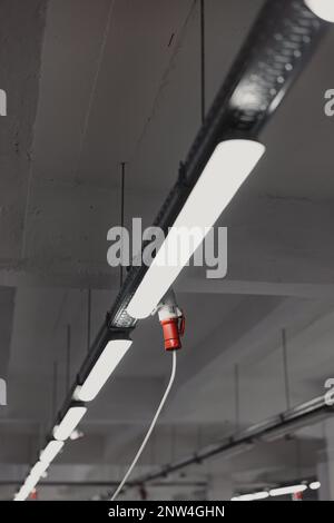 Hanging LED light bulb on ceiling of office building, industrial background Stock Photo