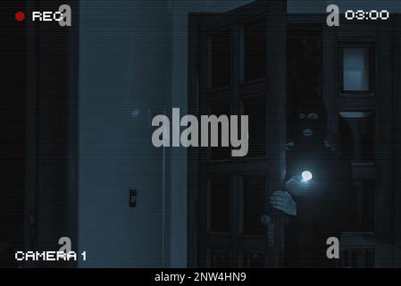 The thief breaks into the house. View through a security camera. Stock Photo
