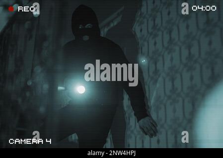 The thief breaks into the house. View through a security camera. Stock Photo