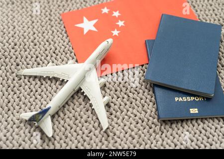 Flag of China with passport and toy airplane. Flight travel concept. Stock Photo