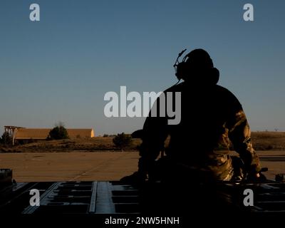 A U.S. Air Force Airman, assigned to the 86th Aircraft Maintenance Squadron, sits on the ramp of a C-130J Super Hercules aircraft during exercise Chasing Sol in Zaragoza, Spain, Jan. 26, 2023. Members of the 86th Airlift Wing, 435th Air Ground Operations Wing and Soldiers assigned to the 21st Theater Sustainment Command’s 5th Quartermaster Company are in Zaragoza to participate in exercise Chasing Sol with the Spanish air force. Stock Photo