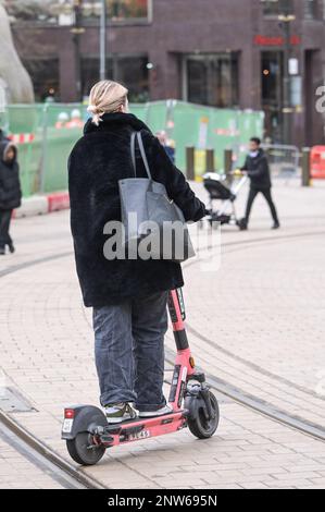 Birmingham, 28th February 2023 - A woman legally rides a Voi electric scooter on the last day before the company ceases operations. - Voi Scooters, the only available hire scooter company in Birmingham will be shutting down their operations on Tuesday 28th February at 11pm. The electric scooters were already thin on the ground in England's Second City after the company said they would be removing the vehicles over the next few weeks. The company ran hire scooters for a trial period but have decided not to continue with the contract and no other company have stepped up to fill the vacancy. Desp Stock Photo