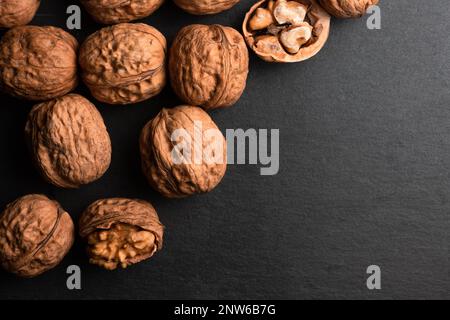 walnuts on black slate background and copy space on right side Stock Photo
