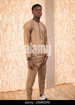 An handsome young african man poses near a wall Stock Photo