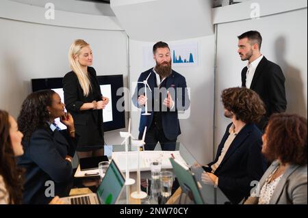 hipster businessman explaining a new project to the teamwork during a meeting. Sustainability concept. Stock Photo
