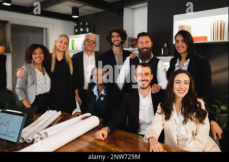 Portrait of elegant teamwork with different ethnicity posing at camera in their workplace. Group of engineers co-working. Stock Photo