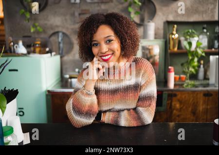 Attractive smiling woman working in a bar. Female looking at camera smiling. Stock Photo