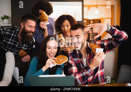 Group of young colleagues or students using computer laptop and having fun during a break. Stock Photo