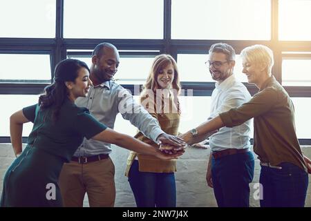 Are you ready, team. Shot of a group of colleagues joining their hands in solidarity at work. Stock Photo