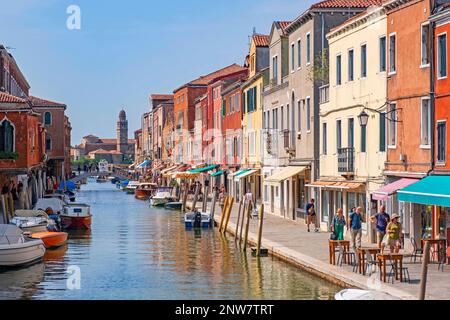 Tourists walk along the canal Rio dei Vetrai at Murano, island famous for its glass making in the Venetian Lagoon near Venice, Veneto, Northern Italy Stock Photo