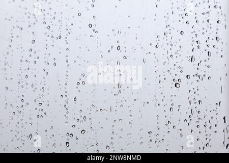 Close-up on raindrops on window during the monsoon. Stock Photo