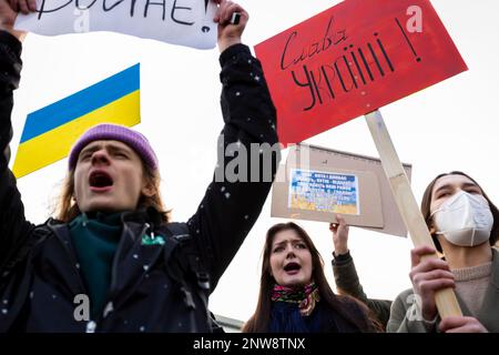 02-27-22 A group of young protesters with makeshift banners shout anti-war chants in Berlin peace rally demo near Brandenburg Gate to support Ukraine Stock Photo