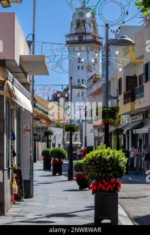 Christmas lights criss-cross a festive Calle Obispo Pérez Cáceres & decorative planters line the street towards the Basilica of Our Lady of Candelaria Stock Photo