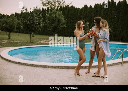 Group of happy young people cheering and having fun outdoors with cider Stock Photo