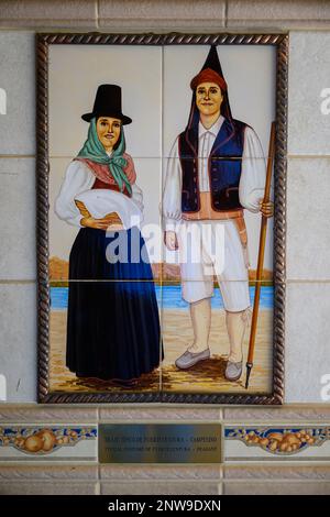 A decorative tile on a wall in the Mercado de Nuestra Senora de Africa shows two peasants in traditional costumes typical of Fuerteventura Stock Photo
