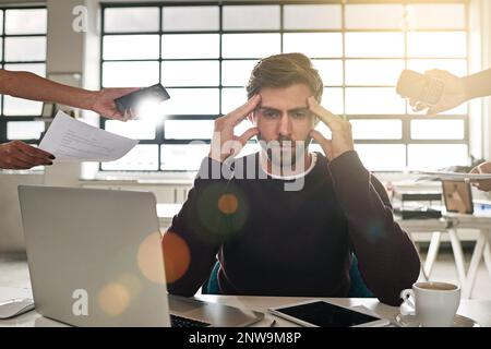 I need help. Shot of a stressed out businessman surrounded by colleagues needing help. Stock Photo