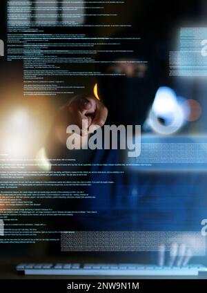 Youve been hacked. Shot of a hacker cracking a computer code in the dark. Stock Photo