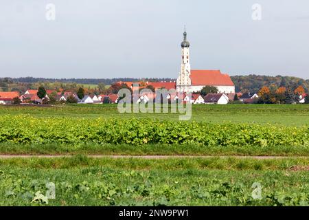 Countryside in Bavaria in Germany showing a traditional onion tower and harvested field Stock Photo