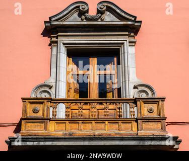 An ornate stone and wooden balcony on a bright ochre building in Calle San Agustin, San Cristobal de La Laguna, Tenerife Stock Photo