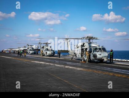 230123-N-EL850-2282 Ionian Sea (Jan. 23, 2023) Helicopters from Helicopter Maritime Strike Squadron (HSM) 46 and Helicopter Sea Combat Squadron (HSC) 5, prepare to take off from the flight deck of the Nimitz-class aircraft carrier USS George H.W. Bush (CVN 77) during flight operations, Jan. 23, 2023. Carrier Air Wing (CVW) 7 is the offensive air and strike component of Carrier Strike Group (CSG) 10 and the George H.W. Bush CSG. The squadrons of CVW-7 are VFA-143, VFA-103, VFA-86, VFA-136, Carrier Airborne Early Warning Squadron (VAW) 121, Electronic Attack Squadron (VAQ) 140, HSC-5, and HSM-46 Stock Photo