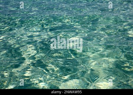 Emerald water texture, transparent sea surface with waves and sandy bottom. Turquoise color, natural background Stock Photo