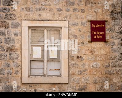 Broken window in stone wall in the Square of Poets, in the Old Town of Budva, Montenegro Stock Photo