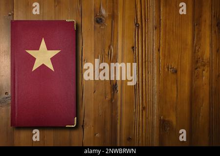 Close-up on a red book with a gilded star symbol in its middle. Stock Photo