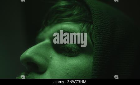 Close-Up Face of Computer Hacker or Programmer at Computer with Green Lights Stock Photo