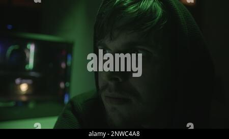 Close-up of Handsome Young Computer Hacker or Programmer Nodding in Agreement while Looking at Monitor Stock Photo
