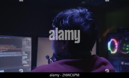 Game Developer or Programmer Developing Code on Computer at Desk Stock Photo