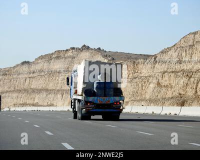 Giza, Egypt, January 26 2023: A big truck loaded with large blocks of stone, limestone, rocks taken from quarries in mountains being transferred on a Stock Photo