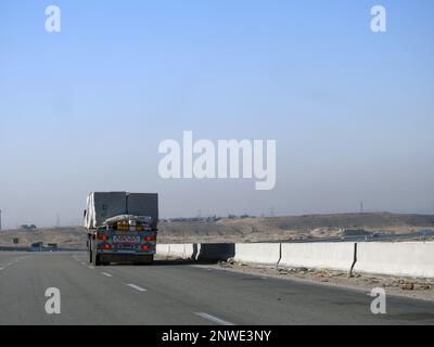 Giza, Egypt, January 26 2023: A big truck loaded with large blocks of stone, limestone, rocks taken from quarries in mountains being transferred on a Stock Photo