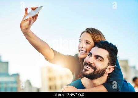 Selfie to look back at this day. Shot of a young couple taking a selfie outside. Stock Photo
