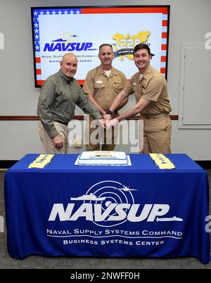 230223-N-PX557-0017  MECHANICSBURG, Pa.  (February 23, 2023)  Retired Cmdr. Thomas LaCoss, Capt. David D. Carnal, commanding officer, Naval Supply Systems Command (NAVSUP) Business Systems Center (BSC), and Lt. j.g. Riley Petsch, project officer assigned to NAVSUP BSC, participate in a cake-cutting ceremony commemorating the 228th birthday of the U.S. Navy Supply Corps. Military members serving in the Supply Corps are trained and employed in supply chain management, operational logistics, contract management, financial management, operations research, and business enterprise management. The br Stock Photo