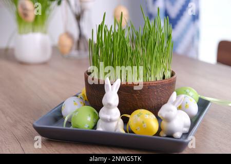 Home easter decor. Green oats, decorative rabbits and eggs Stock Photo