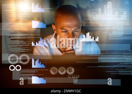 I wont leave here until I crack these codes. Shot of a computer programmer looking through data in the office. Stock Photo
