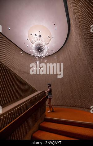 Woman standing in staircase inside the Palm Springs Art Museum. Stock Photo