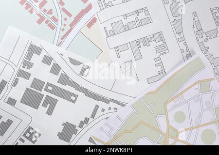 Many different cadastral maps of territory with buildings as background, top view Stock Photo