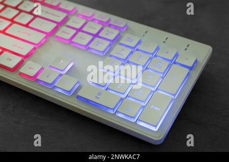 Modern keyboard with RGB lighting on grey table, closeup Stock Photo