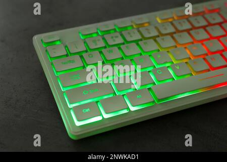 Modern keyboard with RGB lighting on grey table, closeup Stock Photo