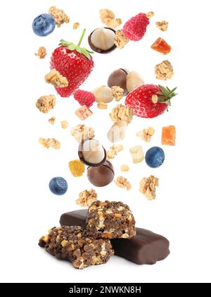 Tasty protein bars and granola with berries and nuts falling on white background Stock Photo