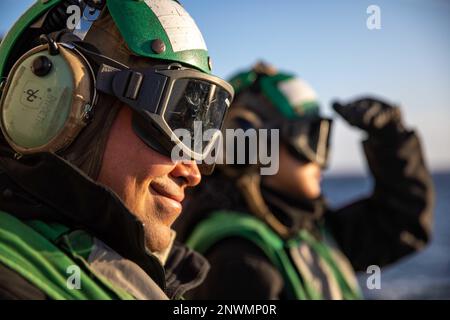 BALTIC SEA (Jan. 13, 2023) Aviation Machinist’s Mate 1st Class Daniel Miranda, left, and Aviation Machinist’s Mate Airman Majorie Rogero, right, assigned to Helicopter Maritime Strike Squadron (HSM) 79, observe a MH-60R Seahawk helicopter on the flight deck of the Arleigh Burke-class guided-missile destroyer USS Roosevelt (DDG 80), Jan. 13, 2023. Roosevelt is on a scheduled deployment in the U.S. Naval Forces Europe area of operations, employed by U.S. Sixth Fleet to defend U.S., allied and partner interests. Stock Photo