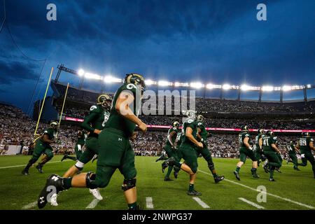 Denver Broncos players run on the field led by McTelvin Agim (95), Marquiss  Spencer (51), Justin Strnad (40), Jamar Johnson (41) with other following  to start an NFL football preseason game against