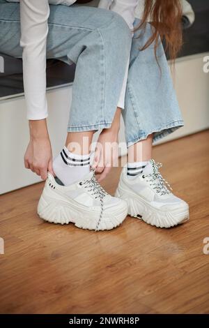 Cropped image ofwoman putting on sneakers Stock Photo